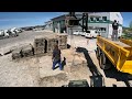 Excavator with siding during preparation under the panel area and stacking the panels