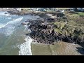 Portstewart Strand in winter sun by drone. Following a surfer via drone 4K