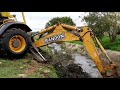 Retroescavadeira limpando córrego. (Backhoe cleaning stream)