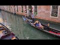 Venezia una gondola parcheggiata e due gondole in movimento