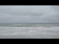 Waves crashing at the beach on an overcast day